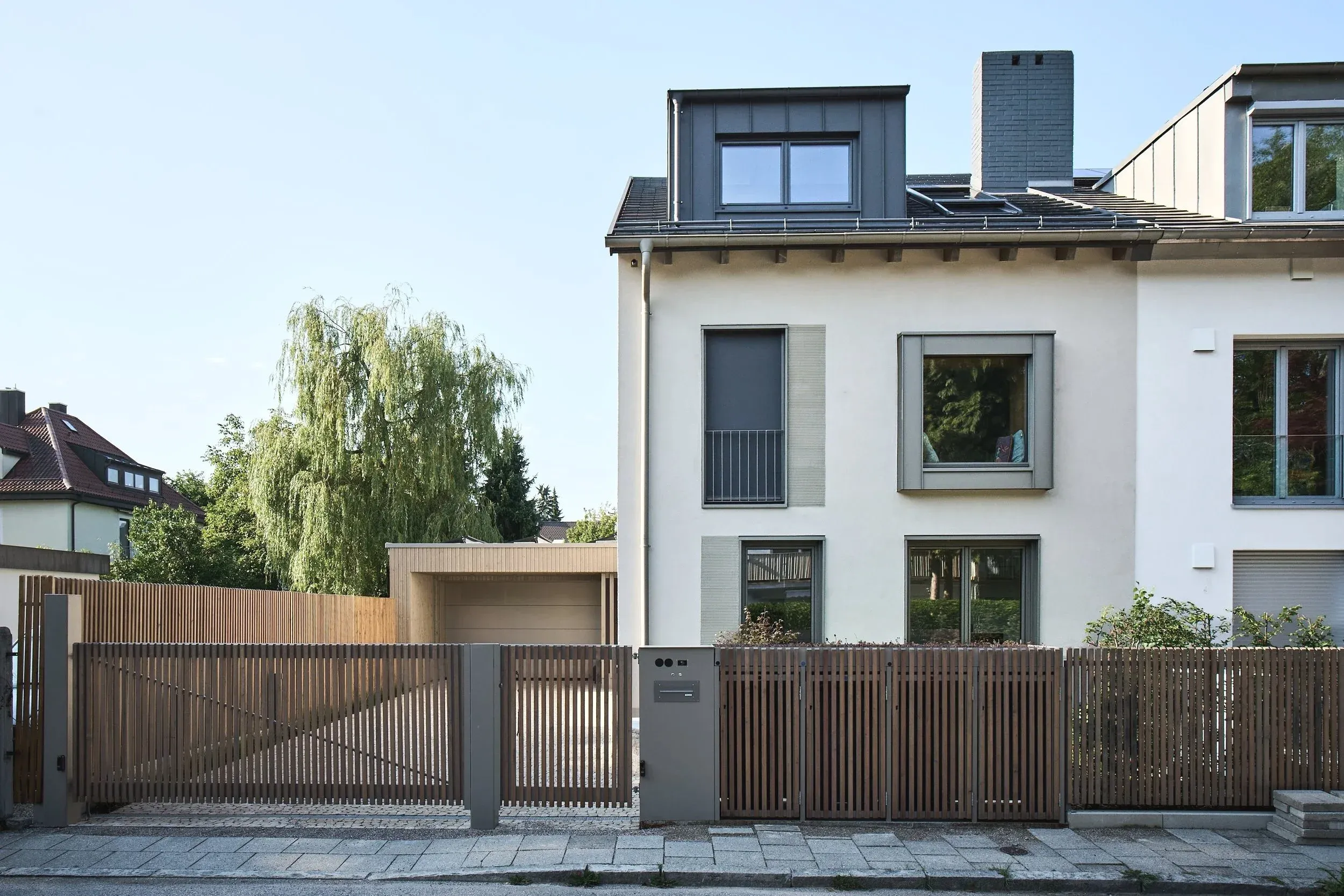 Straßenansicht mit Lamellenzaun und Garage