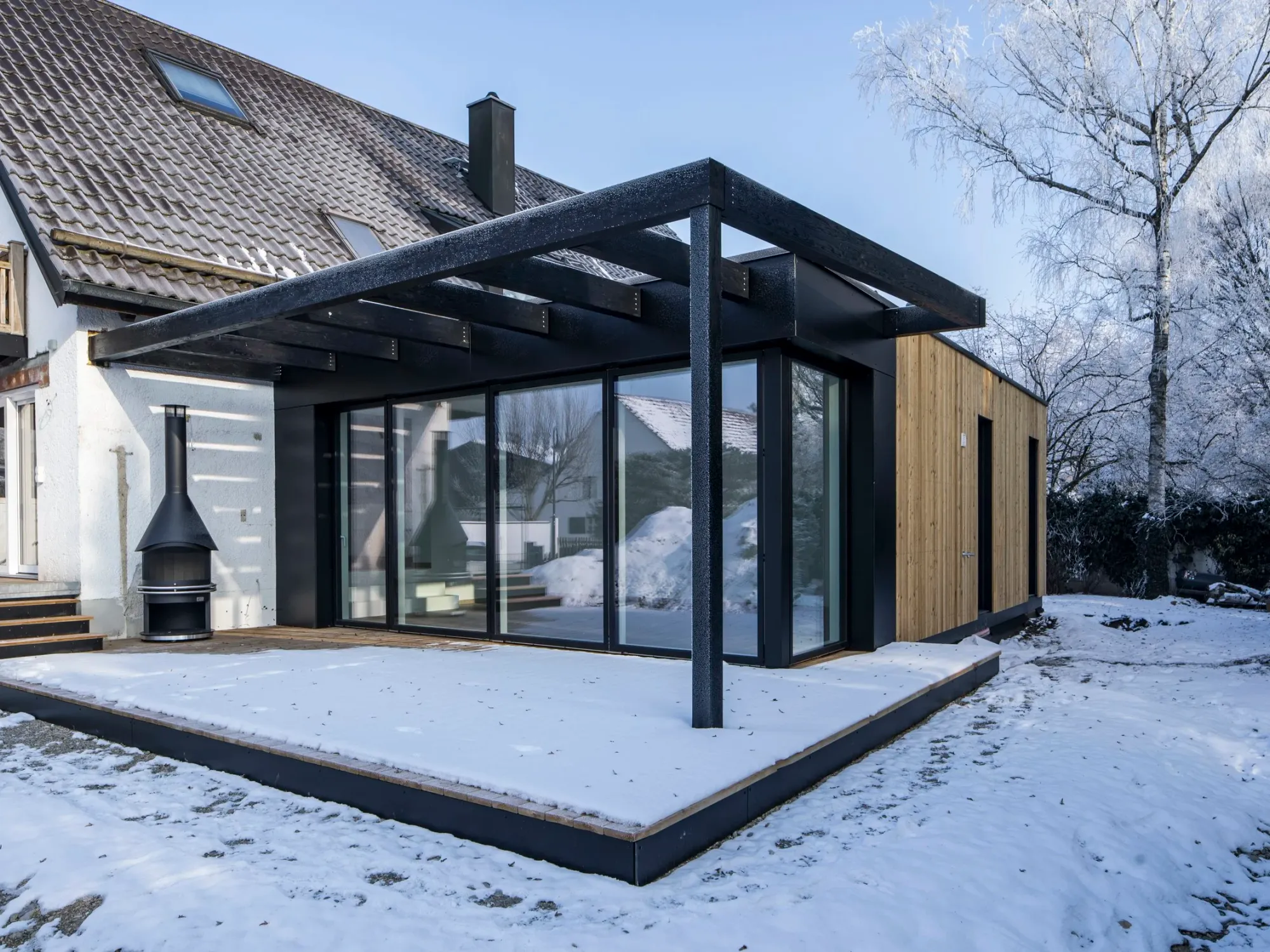 Terrasse mit Pergola und Bestandshaus im Winter