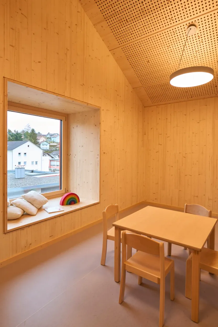 Kleiner Raum ganz in Holz mit Fensternische, Sitzkissen und Kindertisch