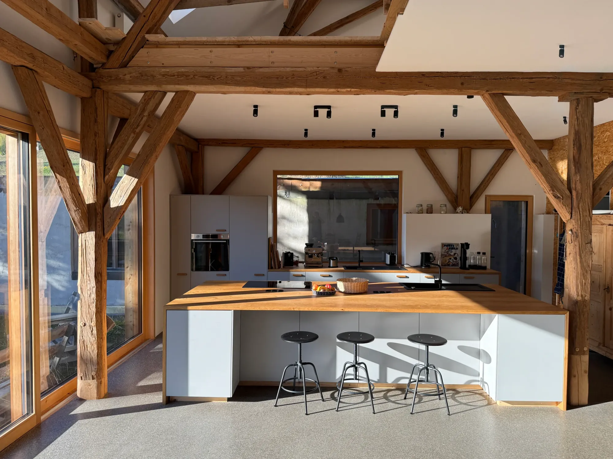Küche mit Holzarbeitsplatte und sichtbarem Holztragwerk